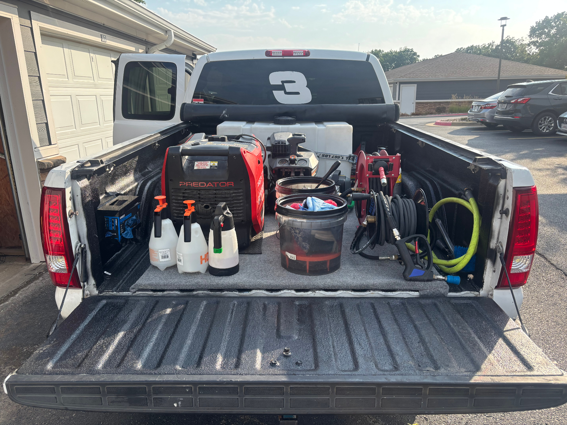Prestige Auto Detail mobile setup: generator, water tank, pressure washer and detailing supplies in a truck bed